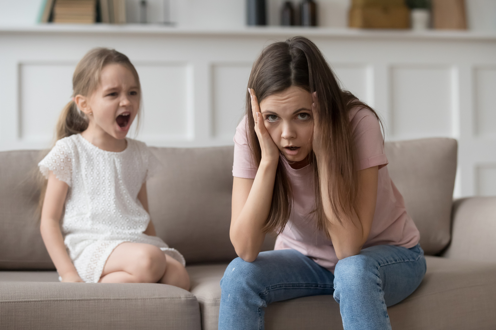 Stressed mother feeling desperate about screaming stubborn kid daughter tantrum